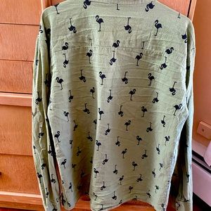 Green long sleeved size M. Collarless. Covered with black flamingo emblems.